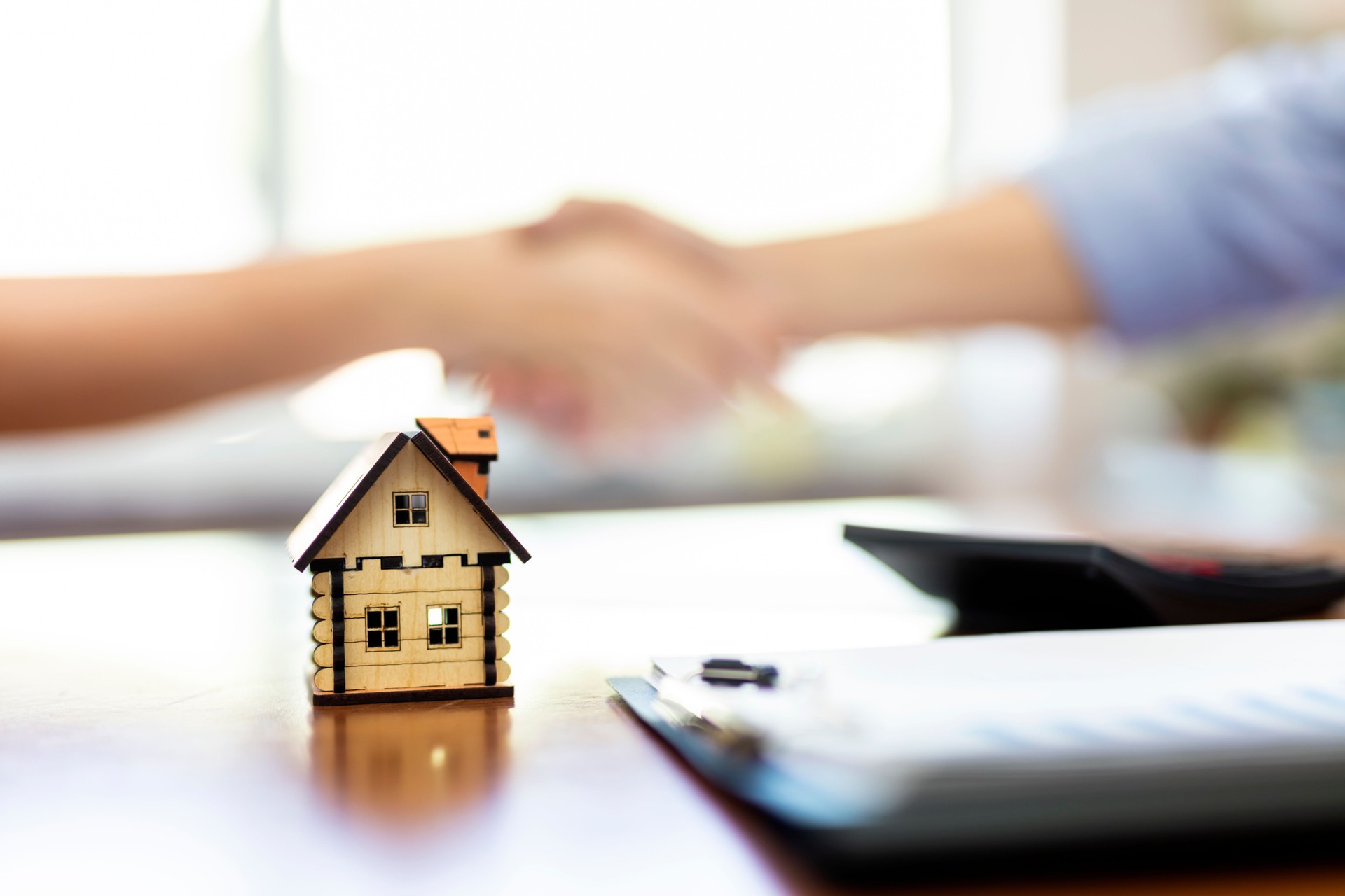 Real estate agent and customers shaking hands together celebrating finished contract